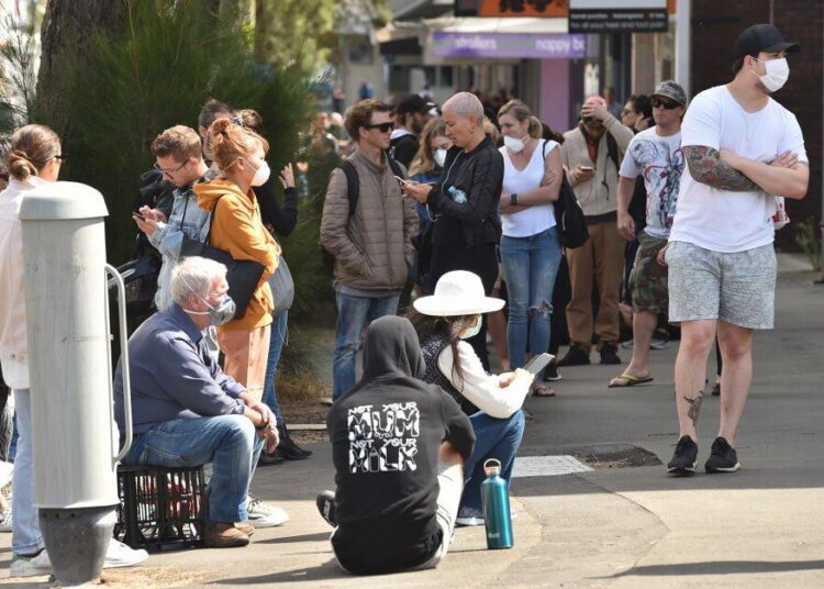 People queue outside a benefits payment centre in Sydney on March 23, 2020. - With the imminent closure of pubs, restaurants, cafes and entertainment venues in Sydney, large queues formed outside Australian unemployment benefit offices as online services crashed as the prime minister warned the coronavirus pandemic would cause an economic crisis akin to the Great Depression. (Photo by PETER PARKS / AFP)