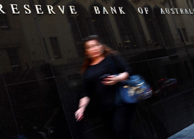 A pedestrian walks past the Reserve Bank of Australia building in Sydney on November 3, 2020. (Photo by Saeed KHAN / AFP)