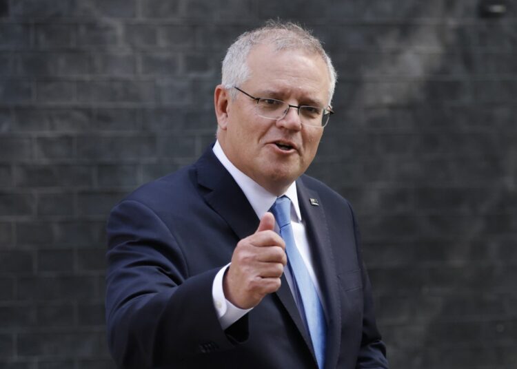 (FILES) In this file photo taken on June 15, 2021 Australia's Prime Minister Scott Morrison gestures as he leaves 10 Downing street in central London.. - Morrison on September 16, 2021 extended an "open invitation" for talks with Chinese President Xi Jinping, after announcing a series of high-tech military purchases spurred by Beijing's growing strength. (Photo by Tolga Akmen / AFP)