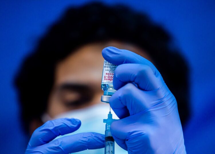 (FILES) In this file photo taken on February 16, 2021 medical worker Robert Gilbertson loads a syringe with the Moderna Covid-19 vaccine to be administered by nurses at a vaccination site at Kedren Community Health Center, in South Central Los Angeles, California. - US pharmaceutical company Moderna on March 12, 2021 agreed to deliver 25 million Covid-19 vaccine shots to Australia by the end of next year as the country deals with a lagging immunization campaign. Moderna will deliver 10 million doses this year and by 2022 deliver 15 million booster shots that are still being tested but meant to neutralize variants of Covid-19, the company and the Australian government said in a statement. (Photo by Apu GOMES / AFP)