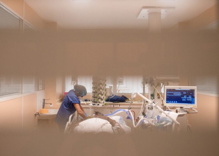 A member of the medical staff tends to a Covid-19 patient under respiratory assistance, in a room of the intensive care unit at the (Centre hospitalier universitaire) in Pointe-a-Pitre, on the French Caribbean archipelago of Guadeloupe, on September 3, 2021. (Photo by Carla BERNHARDT / AFP)