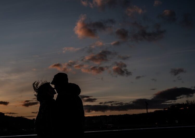 A couple kisses at sunset in Paris on February 5, 2022. - Valentine's Day is celebrated annually on February 14. (Photo by Martin BUREAU / AFP)
