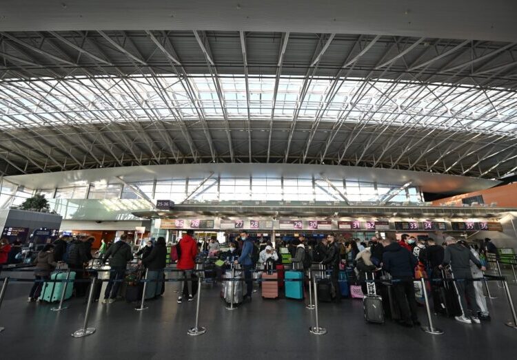 Travellers wait at the check-in counters ahead of their flights at the Boryspil airport some 30 kilimetres outside Kyiv on February 13, 2022. - Ukraine on February 13, 2022, vowed to keep its airspace open to international travel despite Western warnings that Russian troops conducting drills near its borders could invade at any point. (Photo by Sergei Supinsky / AFP)