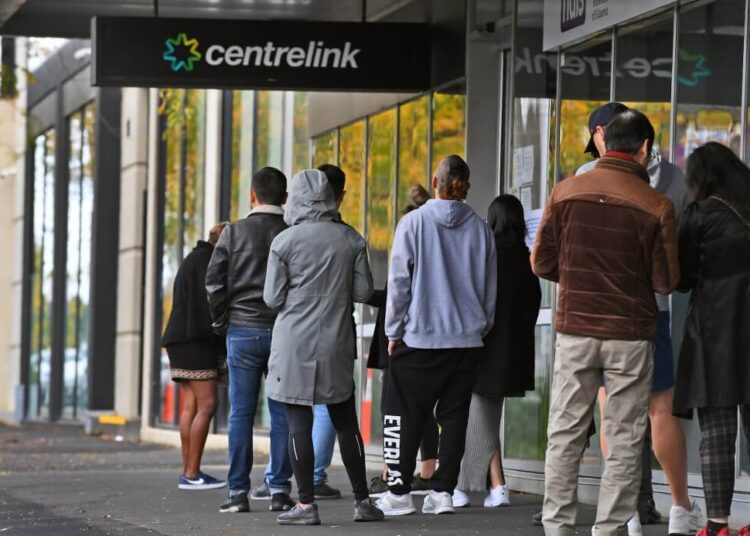 People queue up outside a Centrelink office in Melbourne on April 20, 2020 (Photo by William WEST / AFP)
