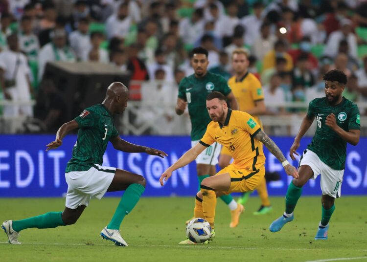 Saudi Arabia's defender Abdullah Madu (L) vies for the ball with Australia's forward Martin Boyle during the 2022 Qatar World Cup Asian Qualifiers football match between Saudi Arabia and Australia, at the King Abdullah Sport City Stadium in the city of Jeddah, on March 29, 2022. (Photo by - / AFP)