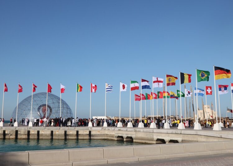 A general view shows flags of the qualified countries for the 2022 World Cup at the seafront of the Qatari capital Doha, on March 30, 2022. (Photo by KARIM JAAFAR / AFP)