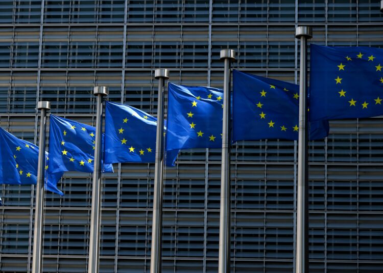 European Union flags fly outside the European Commission building in Brussel on June 16, 2022. (Photo by Kenzo TRIBOUILLARD / AFP)