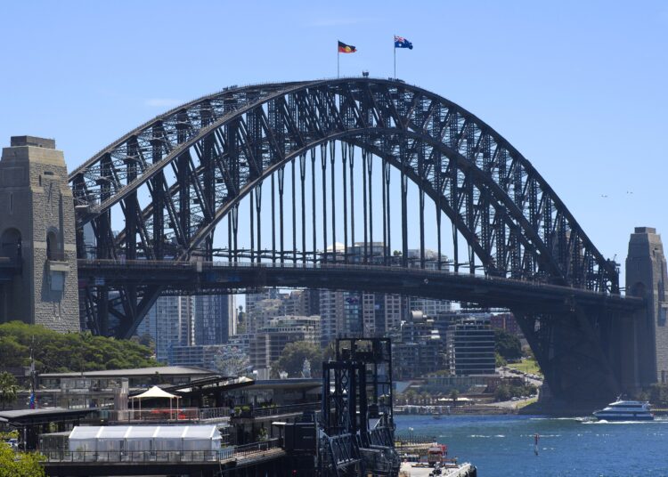 The Australian and Aboriginal flags fly on Sydney Harbour Bridge as part of Australia Day celebrations in Sydney on January 26, 2021. (Photo by Wendell TEODORO / AFP)
