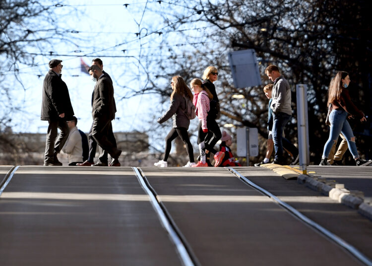 People cross a street in Melbourne on June 28, 2021, after the release of the 2021 Intergenerational Report saying Australia's economy will grow more slowly over the next 40 years than previously expected -- largely due to lower population growth caused by pandemic-related migration decline and a lower fertility rate. (Photo by William WEST / AFP)