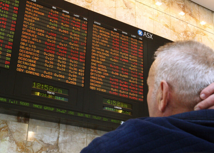 A man studies a fluctuating Australian Securities Exchange board in Melbourne after Australia's central bank slashed interest rates by a full 100 basis points amid fears of a global slowdown sparked by the US-based financial crisis on October 7, 2008. Shares which had been down more than 3.0 percent in early trading, after panic over the scope of the financial crisis sent markets plummeting worldwide, were up around 1.0 percent within minutes of the bank's announcement. AFP PHOTO/William WEST (Photo by WILLIAM WEST / AFP)