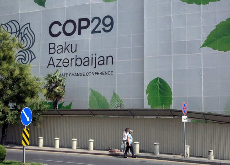 Branding for the COP29 climate conference covers the facade of a building under renovation in the Azerbaijani capital of Baku on September 11, 2024. (Photo by TOFIK BABAYEV / AFP)