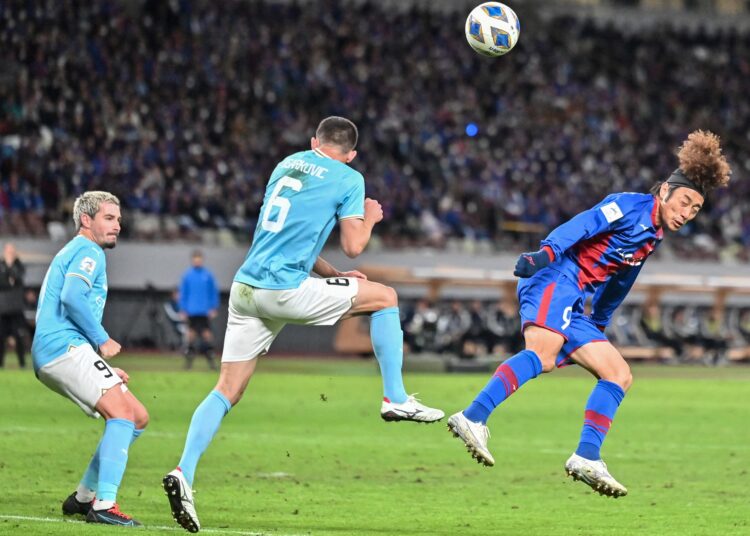 Kofu's Kazushi Mitsuhira (R) heads the ball as Melbourne's Jamie Maclaren (L) and Steven Ugarkovic (C) defend during the AFC Champions League Group H football match between Japans Ventforet Kofu and Australias Melbourne City FC at the National Stadium in Tokyo on November 29, 2023. (Photo by Richard A. Brooks / AFP)