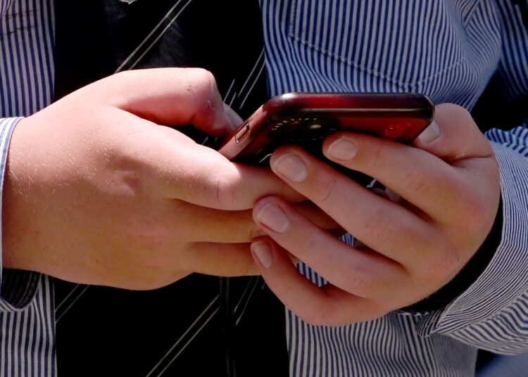 (FILES) A student uses his phone in Melbourne on November 27, 2024, as Australia looks to ban children under 16 from social media with claims social media platforms have been tarnished by cyberbullying, the spread of illegal content, and election-meddling claims. New Zealand's prime minister on May 6, 2025 proposed banning children under 16 from social media, stressing the need to protect them from the perils of big tech platforms. The proposed ban was modelled on that of Australia, which sits at the forefront of global efforts to regulate social media. (Photo by William WEST / AFP)
