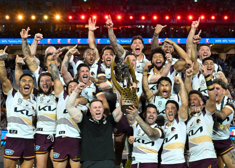 Brisbane Broncos' players celebrate with the trophy after winning the National Rugby League (NRL) Grand Final match between Melbourne Storm and Brisbane Broncos at Accor Stadium in Sydney on October 5, 2025. (Photo by Izhar KHAN / AFP) / --IMAGE RESTRICTED TO EDITORIAL USE - STRICTLY NO COMMERCIAL USE--