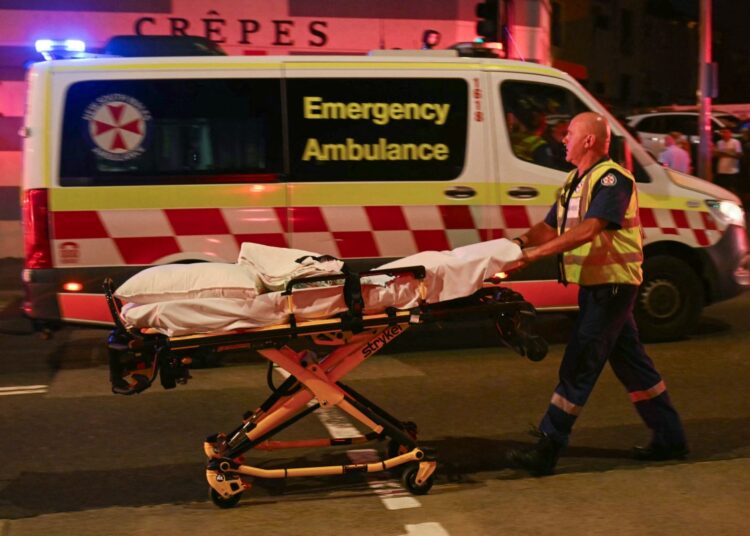 A health worker moves a stretcher after a shooting incident at Bondi Beach in Sydney on December 14, 2025. Australian police said two people were in custody following reports of multiple gunshots on December 14 at Sydney's famed Bondi Beach, urging the public to take shelter. (Photo by Saeed KHAN / AFP)