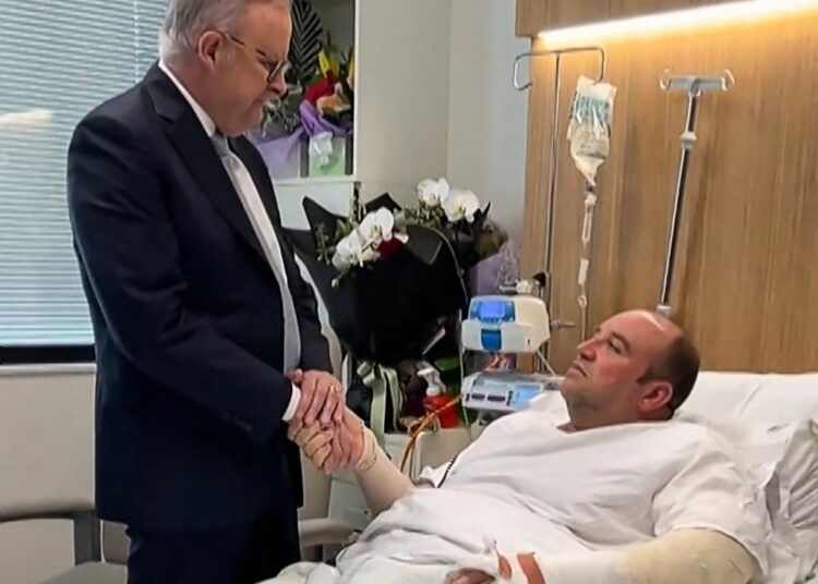 This frame grab from a video posted on the X (formerly Twitter) account of @AlboMP of Australia's Prime Minister Anthony Albanese taken and released on December 16, 2025 shows Albanese (L) meeting Ahmed al Ahmed, the man who disarmed one of the attackers during the Bondi beach attack, in hospital in Sydney. Australia's prime minister visited Bondi Beach shooting hero Ahmed al Ahmed in hospital on December 16, lauding his efforts to help stop the nation's deadliest gun attack in decades. (Photo by X ACCOUNT of @AlboMP / AFP)