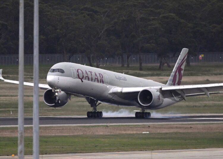 A Qatar Airways plane, carrying Australian women and children returning from Syrian refugee camps where they have been staying since the Islamic State's demise, lands at the airport in Melbourne on May 26, 2026. (Photo by WILLIAM WEST / AFP)
